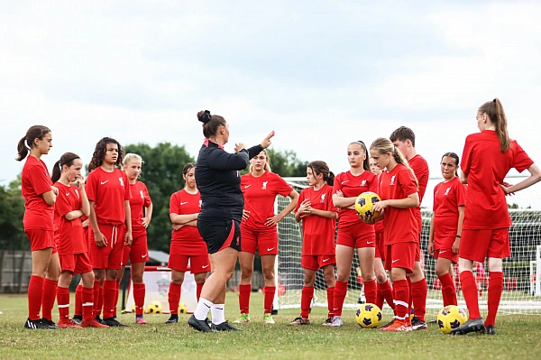 Young player in red uniform at football summer school